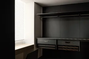 Modern minimalist closet with metal finishes and integrated storage solutions.