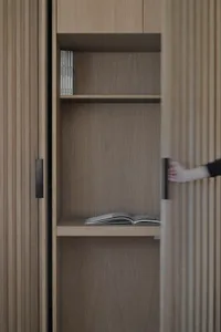 A modern interior design features a wooden shelf with books and a magazine.