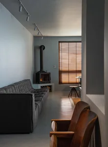 Modern living room featuring a concrete floor, fireplace, and wooden furniture.