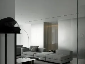 Minimalist living room with fabric seating and glass walls.