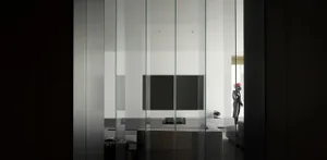 Modern minimalist living room with large glass walls and a sleek, contemporary sofa.