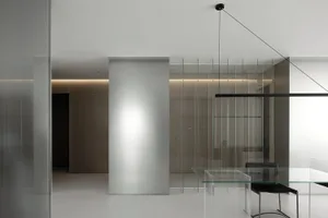 Modern minimalist office interior with glass walls and metal accents.