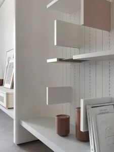 A minimalist bookshelf made of white wood with various shelves and objects.