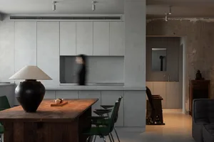 A modern residential kitchen featuring concrete countertops and wooden cabinets.