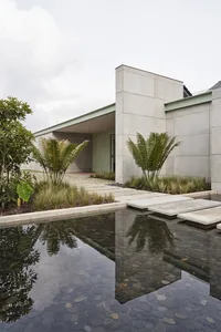 Modern residential exterior with concrete walls and a water feature.