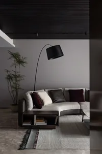 Modern, contemporary living room with minimalist design, featuring a curved sofa, floor lamp, and minimalist decor.