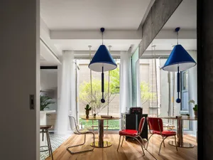 A modern dining room featuring concrete and wood materials.