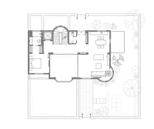 A technical drawing of a modern house's ground floor layout, featuring a living area, bedroom, and staircase.