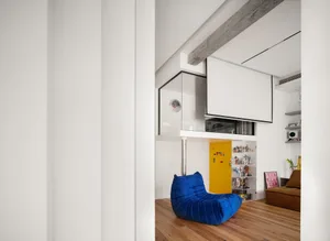 A modern living room featuring a blue beanbag chair on a wooden floor.