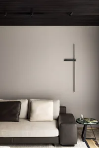 Modern living room featuring a sleek sofa with beige upholstery, leather cushions, and a minimalist wall clock.