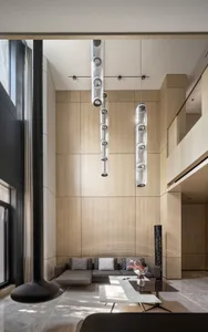 A modern living room with a couch, coffee table, and contemporary lighting fixtures.