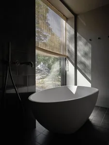 Minimalist bathroom featuring concrete architecture with a view of nature.