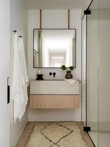 A modern bathroom featuring a concrete vanity and a glass shower door.