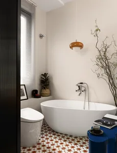 Modern bathroom with a freestanding bathtub, porcelain tiles, and a terrazzo pattern on the floor, featuring a sleek white to