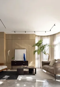 A modern living room with taupe-colored wood paneling, large glass windows, and a comfortable leather sofa.