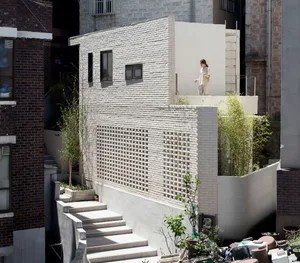 A modern concrete pavilion in an urban backyard setting.