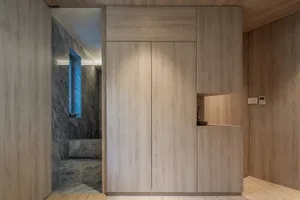 A modern kitchen with minimalist design, featuring wood cabinets.