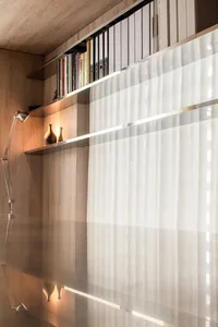 A modern library with transparent glass and wooden shelves.