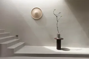 A minimalist living room with concrete elements and a single plant.