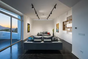A modern living room with grey sofas, minimalist design, and large windows