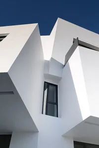White modern minimalist architectural building with metallic window frame and geometric shapes