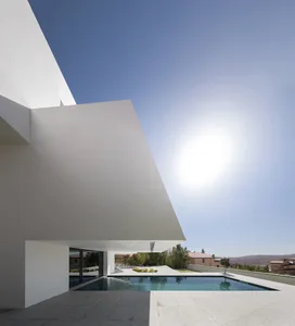 Modern pool house exterior with minimalist design, concrete facade, and outdoor pool.