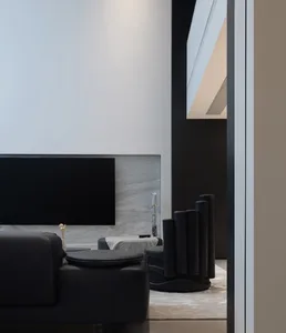 Modern living room featuring black leather furniture and sleek technology elements.