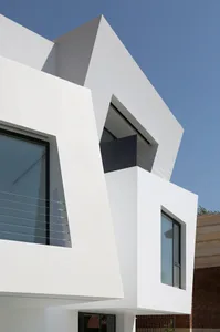 Photograph of a modern residential building with a unique white cube design.