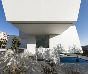 Modern white exterior of a house with concrete steps and a glass window.
