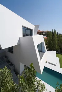 Modernist residential exterior with geometric shapes and large glass windows.