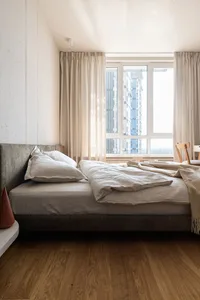 A minimalist bedroom with concrete walls and linen furnishings, showcasing a serene and modern design.