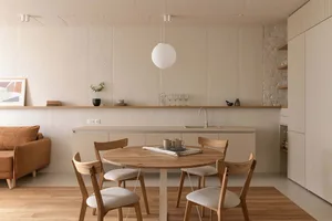 一張簡約住宅廚房的照片，配有木質家具、混凝土背板與層壓檯面。