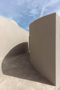 Modern concrete architectural design with curved walls and shadows.
