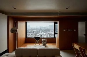 A minimalist living room with a window overlooking a cityscape.