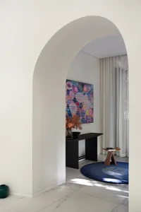 Modern living room with marble floors and decorative seating area.