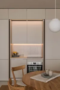 A modern minimalist kitchen featuring concrete countertops and backsplash.