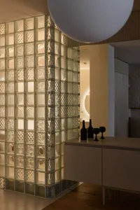 A modern residential kitchen featuring glass block walls.