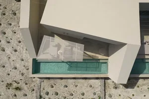 Aerial view of a modern residential layout featuring glass walls and concrete structure.