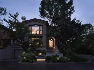 A residential faux-bungalow exterior with a tile roof at dusk.