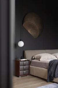 Minimalist bedroom with a bed, nightstand, and wall light fixture