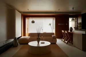 A modern living room with wooden furniture, a round coffee table, and minimalist decor.