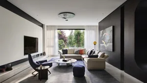 A modern minimalist living room with concrete, glass, and metal materials.