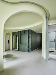 Minimalist living room with modern furniture and decor, featuring a sleek, curved wall and a series of arched doorways.