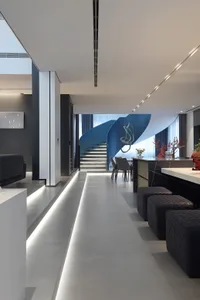 A minimalist, modern interior design featuring a concrete staircase and contemporary furniture.