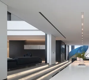 Modern living room with a minimalist design featuring a glass wall and sleek furniture.
