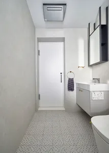 A modern bathroom with concrete tiles on the floor and light-colored walls.