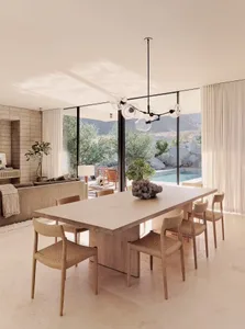 Modern dining room featuring a large natural wood dining table with six chairs, a minimalist chandelier, and a plush couch wi