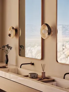 Modern bathroom with minimalist design, featuring marble countertops and walls, and a large window overlooking mountains.