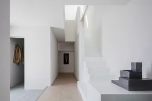A modern interior space with concrete elements, featuring a minimalist design and open-plan layout.