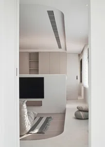 Modern minimalist living room featuring concrete walls and floor, minimalist furniture, and a sleek black TV console.